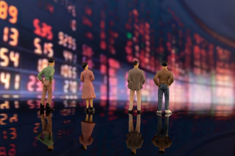 ETF Fundos de indices: em segundo plano uma tela mostrando as oscilações do mercado financeiro e a representação de pessoas em bonequinhos.