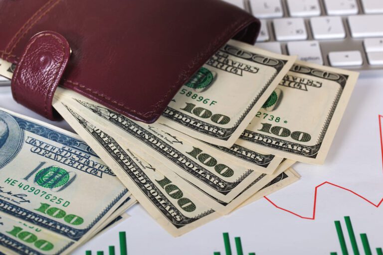 como investir em dólar: uma carteira marrons em cima da mesa com dólar dentro.