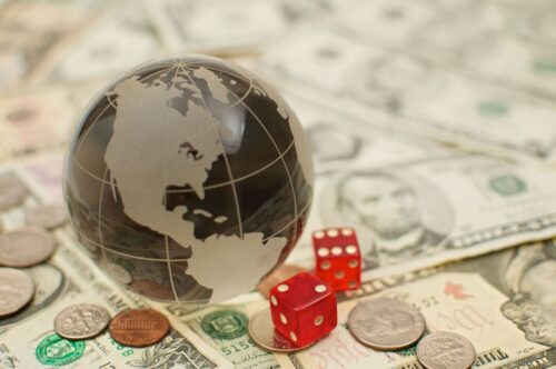 Um pequeno globo posicionado em cima de notas de dólar representa a macroeconomia