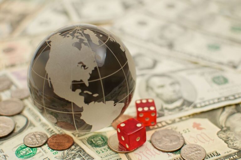 Um pequeno globo posicionado em cima de notas de dólar representa a macroeconomia