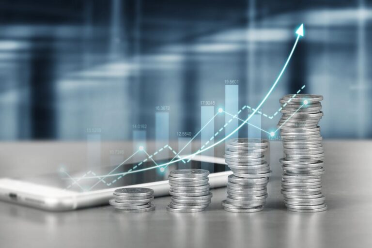 Juros Sobre Capital Próprio: pilhas de moedas na cor prata em sequência e com gráficos.