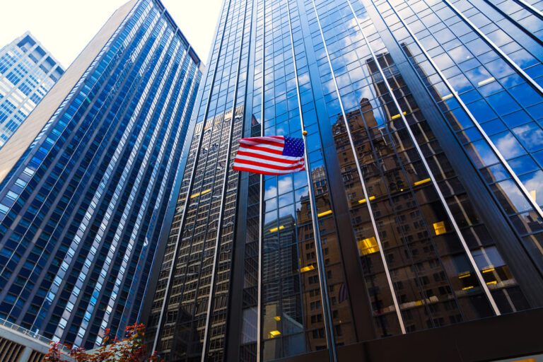 bdr de reits: prédios com uma bandeira dos EUA na frente.