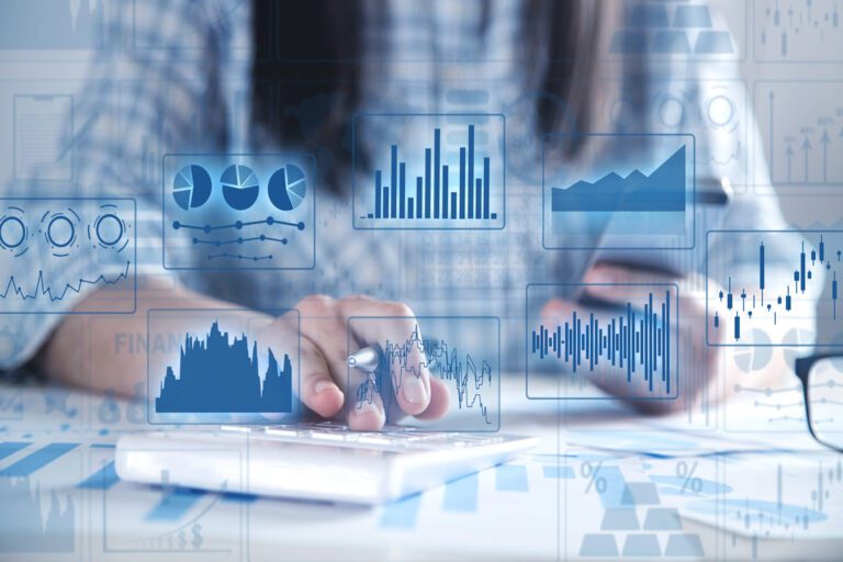aplicações financeiras: algumas representações de modelos de gráficos no primeiro plano, como gráfico em barra, coluna, pizza etc e em segundo plano uma mulher usando uma calculadora.