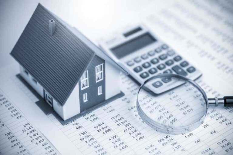 quanto rende um fundo imobiliário: A imagem está em escala de cinza, representando uma casa e ao lado uma calculadora e uma lupa.