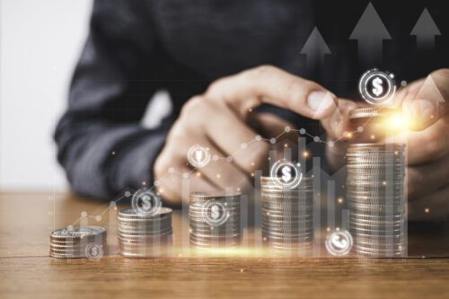 swap: um homem, empilhando algumas moedas douradas e um gráfico de barras em primeiro plano.