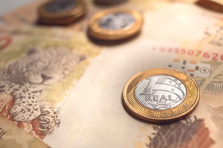 letra do tesouro nacional: uma nota de 50 reais e algumas moedas de um reais em cima.