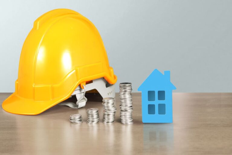 INCC: Pilhas de moedas em ordem crescente e uma casa azul do lado e um capacete amarelo de construção civil.