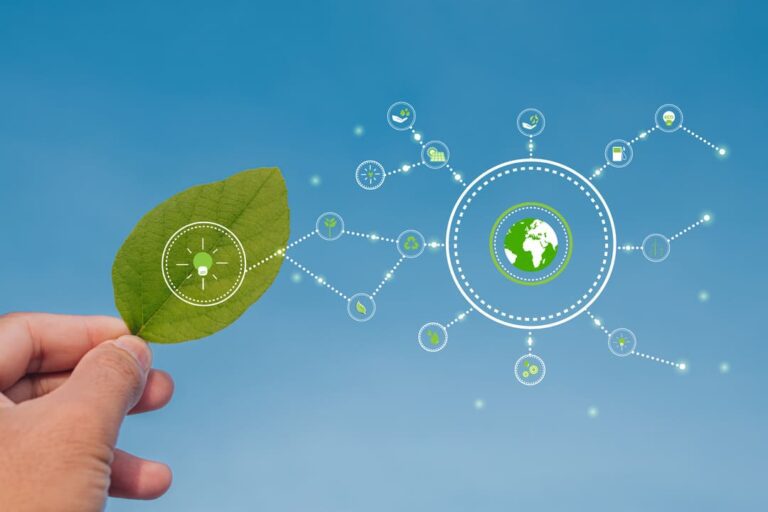 Mão segurando folha verde e ilustração de ícones do meio ambiente interligados em fundo azul, representando o hidrogênio verde.