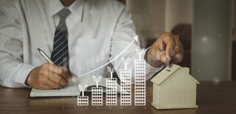 Homem de roupa social anotando em agenda enquanto coloca moedas em um cofre em formato de casa. Um gráfico de moedas em ordem crescente se destaca à frente do homem, aludindo ao ato de investir em imóveis.