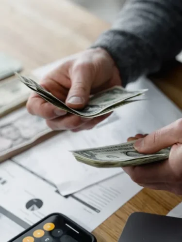 Como economizar dinheiro: homem segurando cédulas de dinheiro nas mãos.