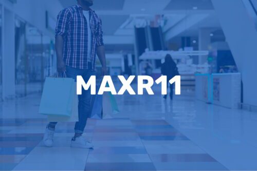Pessoa com sacolas de compras em um shopping, com a palavra MAXR11 em destaque.