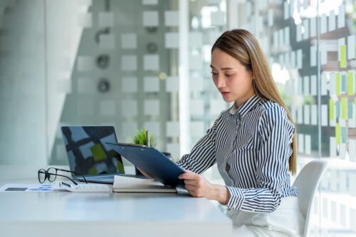 Mulher analisando gráficos de ações, destacando a presença feminina no mercado financeiro e as mulheres na Bolsa de Valores.