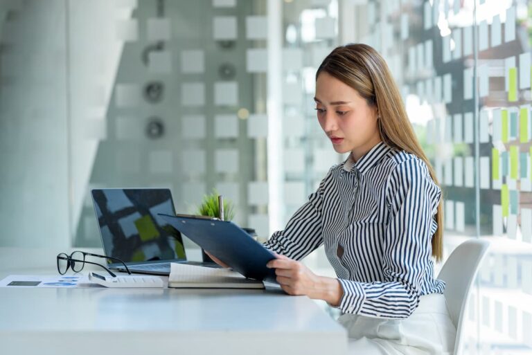 Mulher analisando gráficos de ações, destacando a presença feminina no mercado financeiro e as mulheres na Bolsa de Valores.