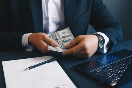 Executivo contando dinheiro, simbolizando quanto ganha um executivo.