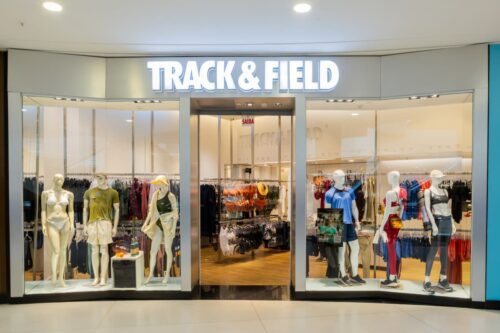 Loja da Track&Field (TFCO4) exibindo manequins com roupas esportivas variadas em um shopping, destacando a moda esportiva premium.