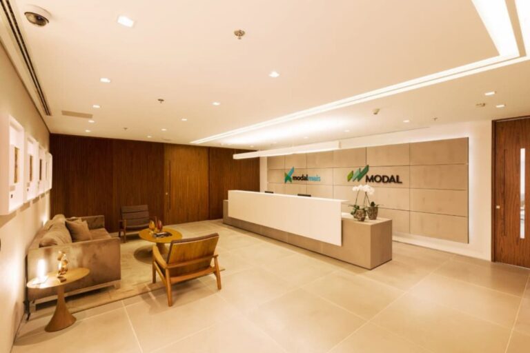 Recepção moderna do Banco Modal com logos do ModalMais e Banco Modal (MODL11) em um espaço iluminado e acolhedor.