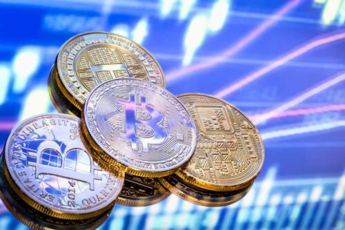 Várias moedas de criptomoedas empilhadas com fundo de gráficos, representando criptomoedas promissoras para 2025.