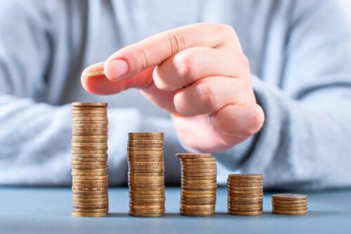 Imagem ilustrando o conceito de empresas mais valiosas do Brasil com pilhas de moedas simbolizando crescimento financeiro.