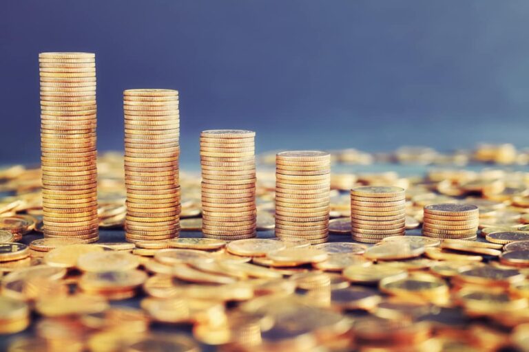 Pilhas de moedas douradas representando o conceito de valor de mercado em investimentos e crescimento financeiro.