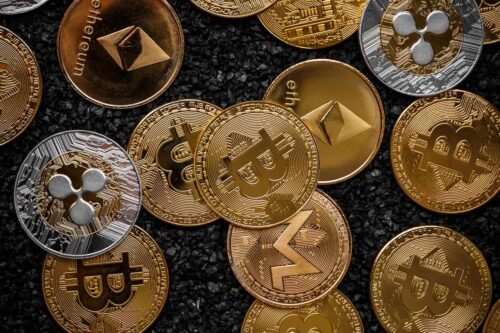 Imagem com várias moedas físicas representando criptomoedas como Bitcoin, Ethereum e Ripple, representando as melhores corretoras de criptomoedas do Brasil.