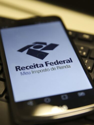Imagem de um celular com a logo da Receita Federal, represetando a declaração do Imposto de Renda 2025.