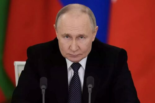 Vladimir Putin aparece sério em frente a bandeiras, representando que a Rússia aceita cessar-fogo contra a Ucrânia.