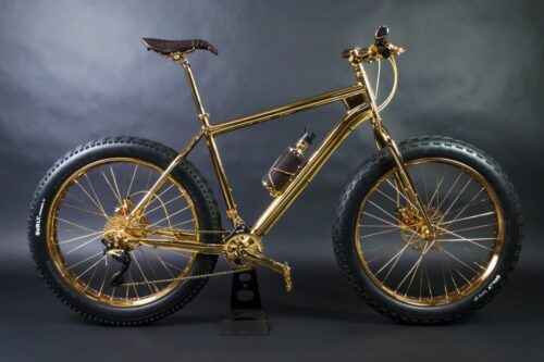 House of Solid Gold 24K Gold Extreme Mountain Bike, a bicicleta mais cara do mundo, com estrutura folheada a ouro e detalhes luxuosos, exposta em fundo neutro.