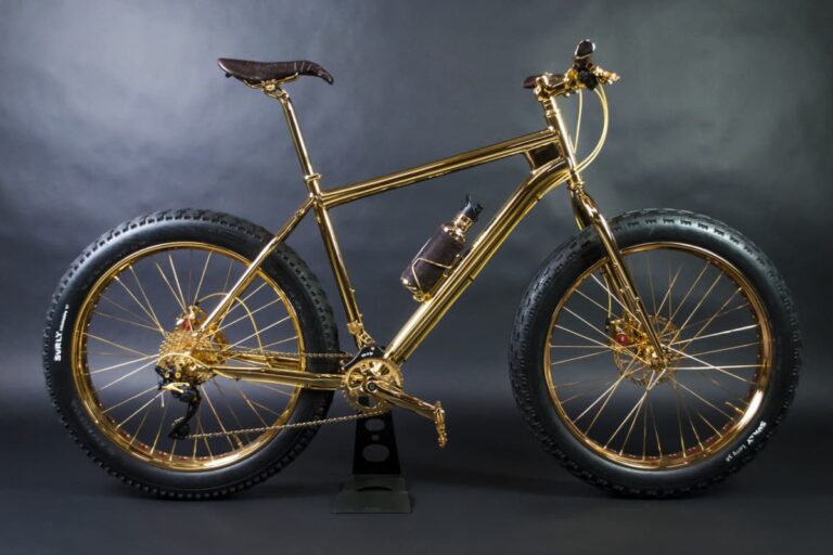 House of Solid Gold 24K Gold Extreme Mountain Bike, a bicicleta mais cara do mundo, com estrutura folheada a ouro e detalhes luxuosos, exposta em fundo neutro.
