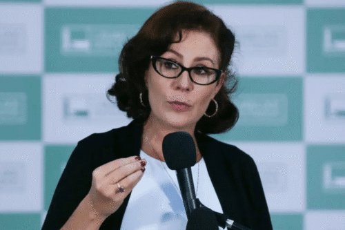 Carla Zambelli deixa o Brasil e anuncia pedido de licença do mandato após condenação do STF, em uma declaração pública com microfone.