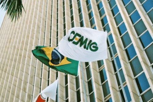 Bandeira da Cemig (CMIG4) ao vento em frente a um prédio moderno, ilustrando análise técnica que aponta alta para as ações em 2025.