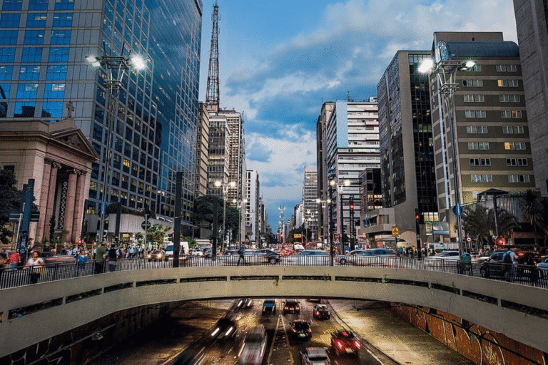 Foto das ruas da São Paulo com tráfego intenso e carros em movimento.