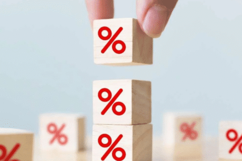 Foto de uma pessoa empilha blocos de madeira com sinais de porcentagem.