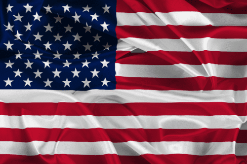 Foto da bandeira dos Estados Unidos, , com listras vermelhas e brancas e um campo azul repleto de estrelas brancas.