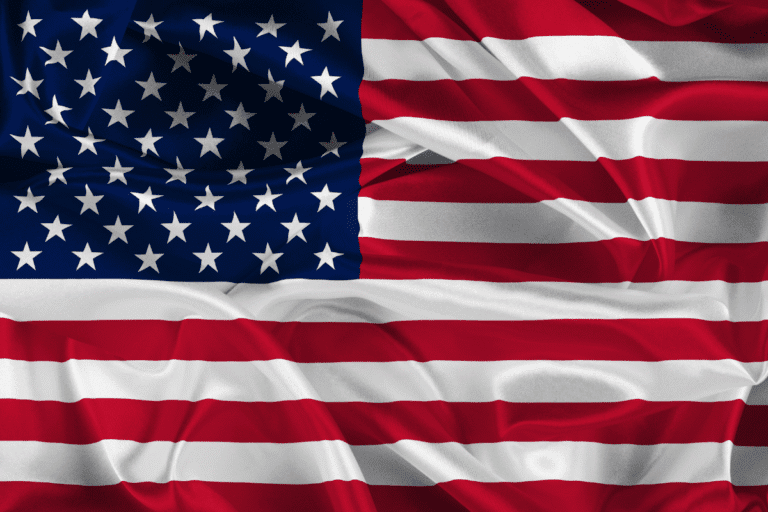 Foto da bandeira dos Estados Unidos, , com listras vermelhas e brancas e um campo azul repleto de estrelas brancas.