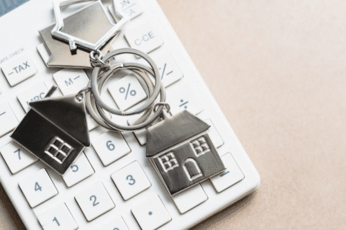 Imagem de uma calculadora acompanhada de chaves de casa.
