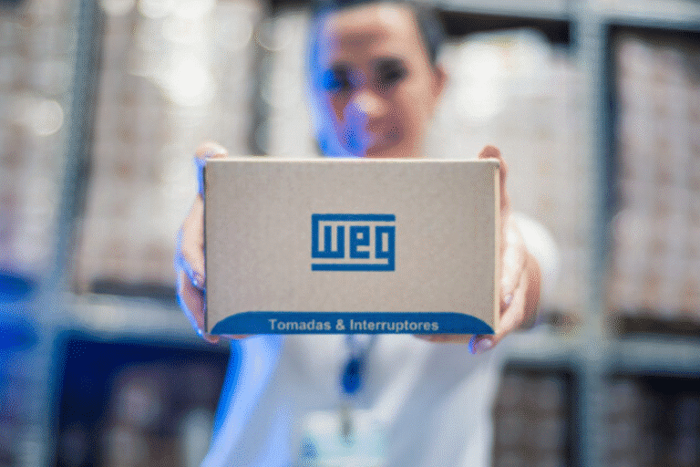 Foto de uma pessoa segurando uma caixa de papelão com o logotipo da WEG.