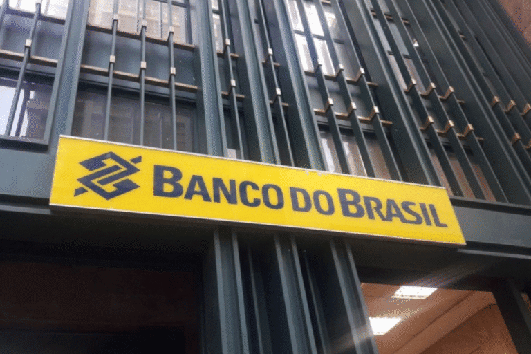 Fachada de uma agência do Banco do Brasil com placa amarela e letreiro em destaque, exibindo a logo e nome do banco.