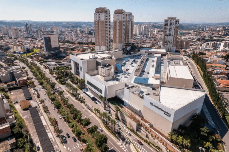 Vista aérea do Shopping Center Iguatemi na cidade de São Paulo, com vários prédios altos ao fundo e ruas com movimento intenso.