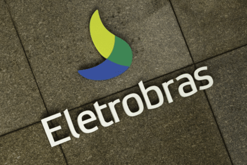 Imagem do logotipo da empresa Eletrobras em um piso de pedra. O logo apresenta uma forma estilizada com cores verde, amarelo e azul, representando energia renovável e sustentabilidade, junto ao nome Eletrobras em destaque.