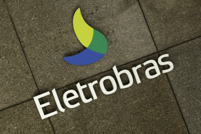 Imagem do logotipo da empresa Eletrobras em um piso de pedra. O logo apresenta uma forma estilizada com cores verde, amarelo e azul, representando energia renovável e sustentabilidade, junto ao nome Eletrobras em destaque.