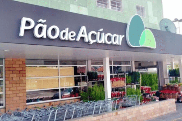 Fachada de uma loja chamada Pão de Açúcar, com carrinhos de compras na frente e produtos de supermercado expostos.