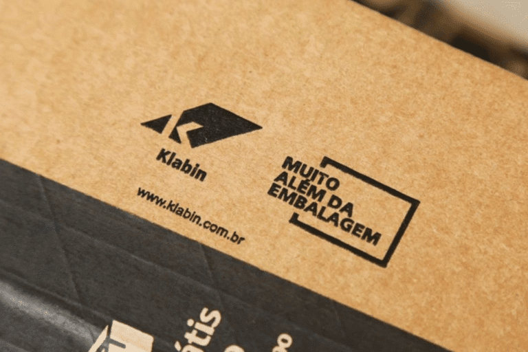 Embalagem de papel kraft com marcação de reciclagem "Muito além da embalagem" da Klabin, reforçando a sustentabilidade na embalagem de produtos.