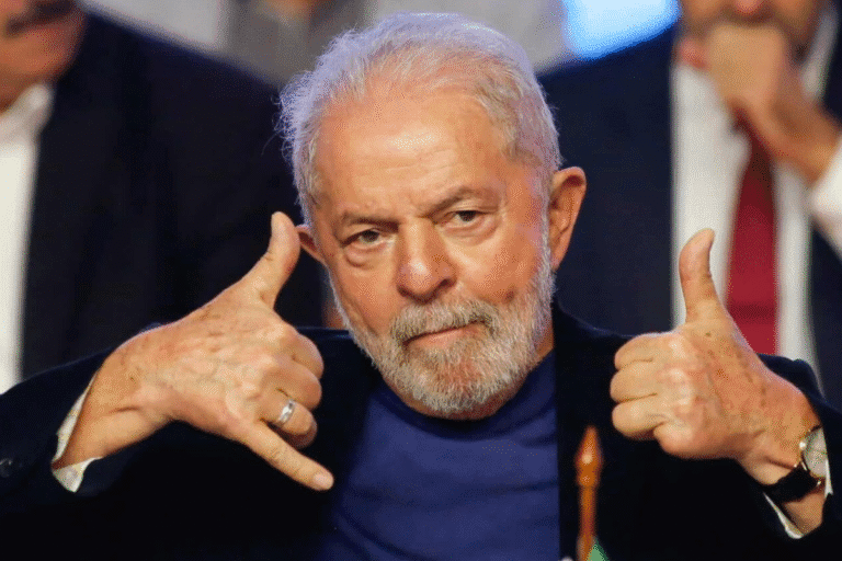 Lula, fazendo sinal de telefone com as mãos, em ambiente formal.