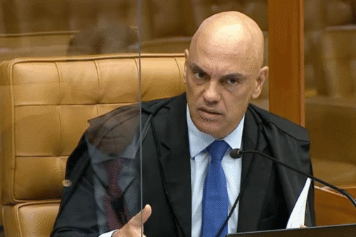 Alexandre de Moraes, em sessão, fazendo uma expressão séria enquanto fala, com fundo de tribunal ao fundo.