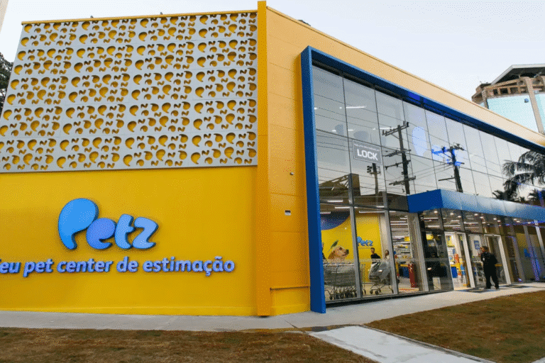 Fachada do Petz, pet center de estimação em uma loja com design moderno e fachada amarela com detalhes azuis, vidro grande na entrada e decoração interna visível.