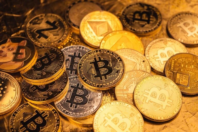 Imagem com diversas moedas físicas representando criptomoedas para investir, incluindo Bitcoin, Ethereum e Dogecoin.