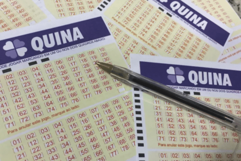 Imagem de uma cartela de aposta na Quina, jogo de loteria, com números marcados e uma caneta em cima, descrevendo detalhes de apostas na loteria brasileira.