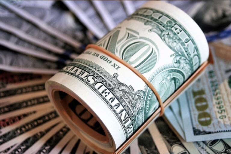 Nota de cem dólares Americanos e notas de dinheiro de cem dólares formando um rolo de dinheiro, simbolizando riqueza e estabilidade financeira.