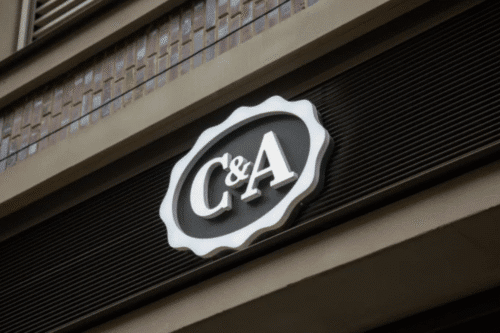 LogoC&A exibido na parede lateral de um prédio, representando a identidade da marca.