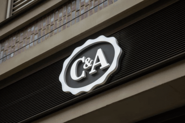 LogoC&A exibido na parede lateral de um prédio, representando a identidade da marca.